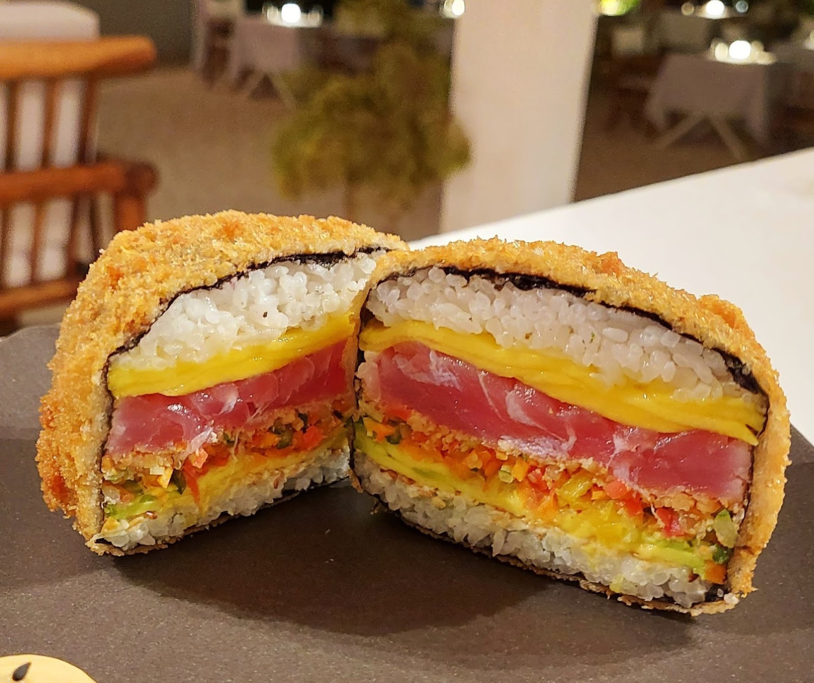 Sezione di un roll croccante fritto in panko con tonno, tamago e verdure