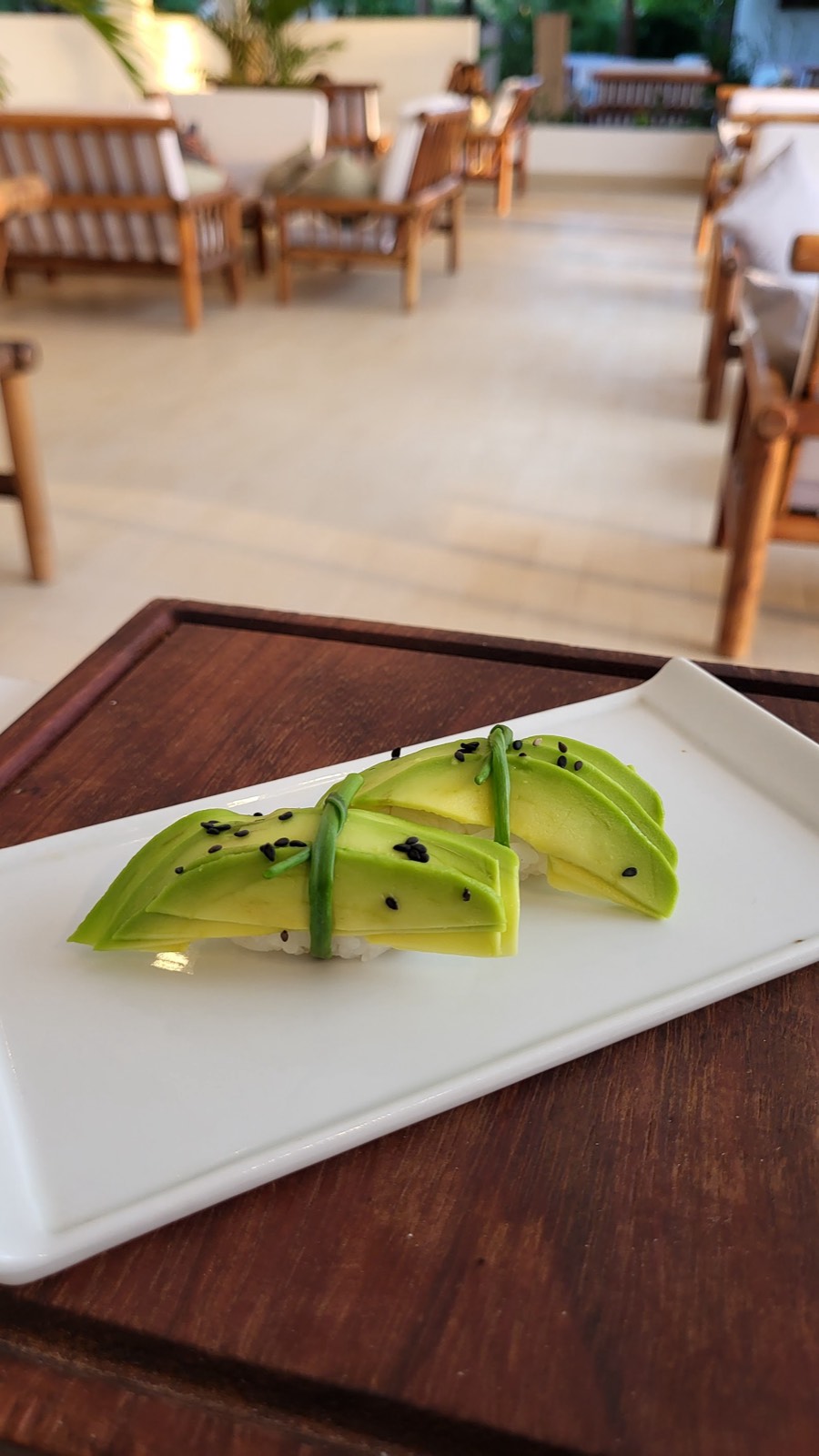 Elegante nigiri all'avocado con sesamo nero su un piatto bianco